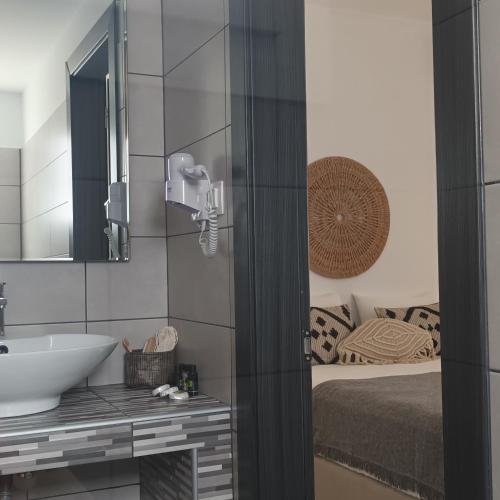 a bathroom with a sink and a bed at Maison Kalogiannis in Patitiri