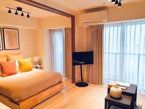 a bedroom with a bed and a flat screen tv at Section L Residence Asakusa East in Tokyo