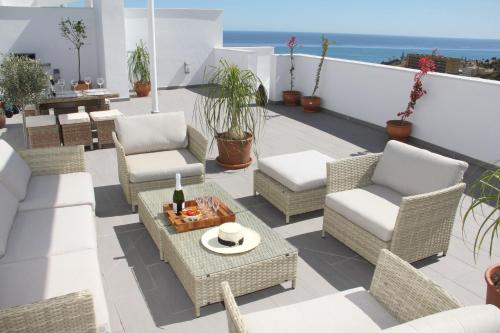 a patio with wicker chairs and a table at Amazing Penthouse in Costa del Sol in Rincón de la Victoria