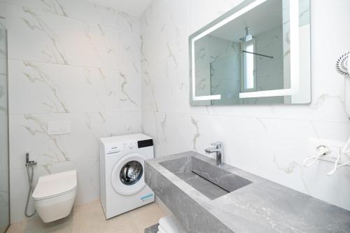 a bathroom with a washing machine and a sink at Hotel Aluor in Vlorë