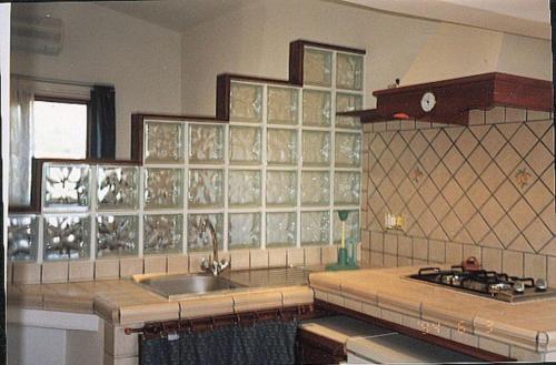 斯佩隆加的住宿－DANYGIO - MANSARDA SPERLONGA，厨房配有水槽和玻璃瓷砖台面。