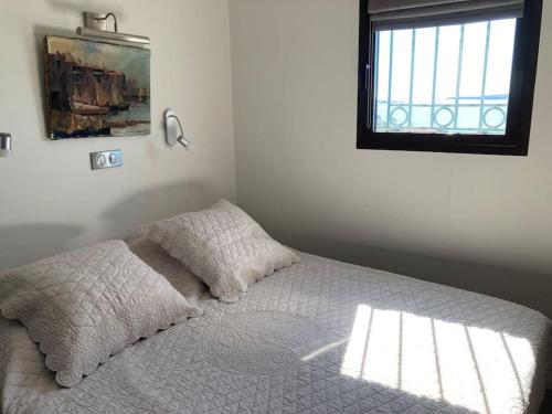 une chambre avec un lit blanc avec une fenêtre dans l'établissement Cannes appt 4 pers 6N, à Cannes