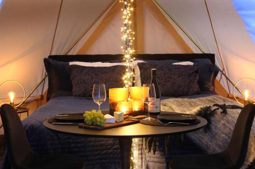 a table with wine glasses and lights on a bed at Urshult Glamping in Urshult