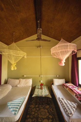 a room with two beds and two umbrellas at Bardia Riverside View Park Resort - FR and EN speaking in Bhurkīā