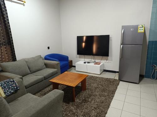 - un salon avec un canapé et une télévision dans l'établissement ريحانة حى الخبر للشقق الفندقيه, à Khobar