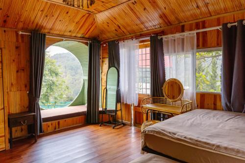 um quarto com uma cama e uma grande janela em Hoàng Gia Trang, The Rustic Garden em Xuan An