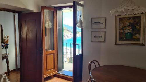 a dining room with a door open to a balcony at La Terrazza sul Mare Sea View - near best beaches in Monterosso al Mare