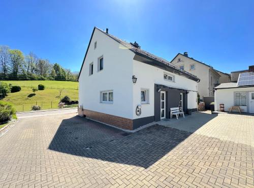 a white house with a brick driveway at Luxuriöse Ferienwohnung in Chemnitz - Apartment B28 für 2 plus 2 Gäste in Chemnitz