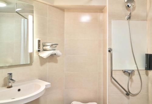 uma casa de banho com um chuveiro e um lavatório. em B&B HOTEL Paris Porte de la Villette em Paris