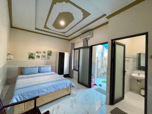 a bedroom with a large bed and a bathroom at T'H Homestay in Mui Ne