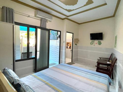 a bedroom with a bed and a sliding glass door at T'H Homestay in Mui Ne