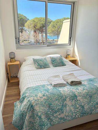 1 dormitorio con cama y ventana grande en Marina appartement sur l’eau, en Le Grau-du-Roi