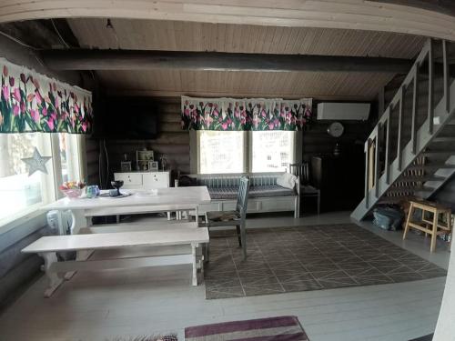 a room with a table and chairs and a staircase at Cottage by the Muonio river for 6 person in Kolari