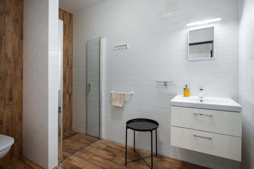 a white bathroom with a sink and a stool at Bohem Prague Hotel in Prague