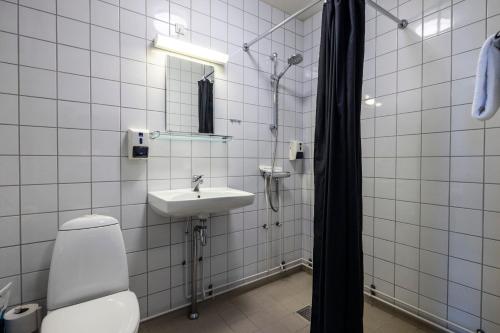 y baño con aseo, lavabo y ducha. en HOTEL SØMA Aasiaat, en Aasiaat