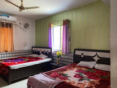 two beds in a room with green walls at Hotel Shobha and Tent House in Patrātu