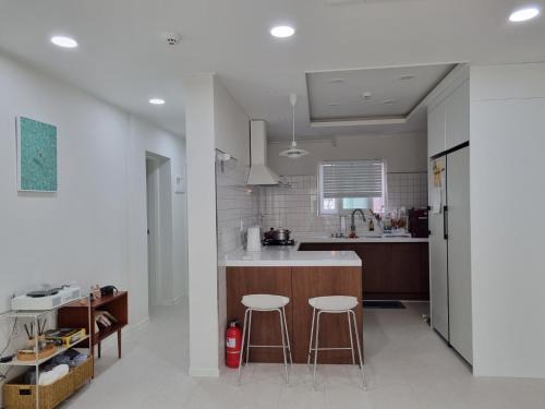 a kitchen with a counter and two stools in it at Calmers in Pohang