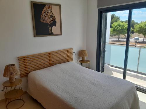 een slaapkamer met een bed en een groot raam bij Chalet Alcocebre Residencial Dulcinea in Alcossebre