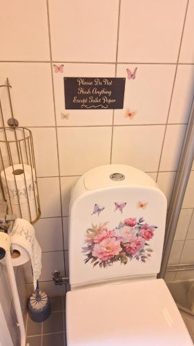 un aseo en un baño con un letrero en la pared en Room near Triangeln Station- shared kitchen and bathroom, en Malmö