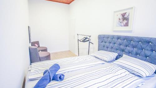 1 cama con cabecero azul y 2 toallas azules en Comfortable Accommodations in the Alterlaa Area LV3 en Viena