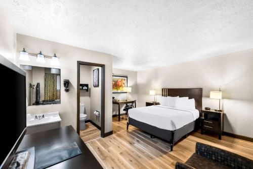 Americas Best Value Inn Marquette في ماركيت: غرفه فندقيه بسرير وحمام