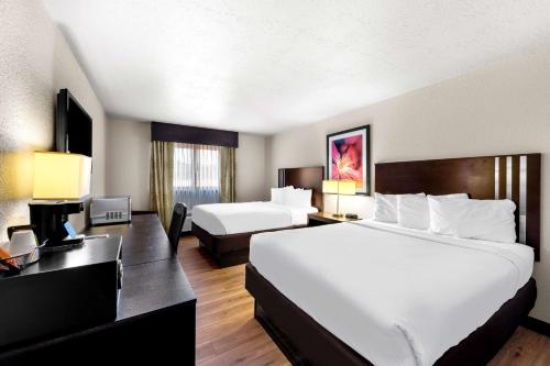 a hotel room with two beds and a desk at Americas Best Value Inn Marquette in Marquette