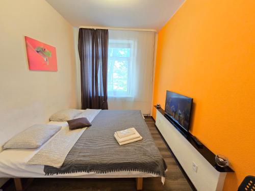 um quarto com uma cama com uma parede laranja em 6 Studio apartment - Orange em Klaipėda