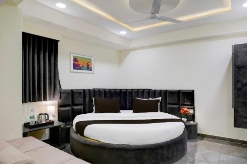 um quarto com uma cama grande e um sofá em OYO Hotel Sunset em Ahmedabad