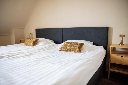 a large bed with two pillows on top of it at Hotel Restaurant BEAU in Bergeijk