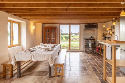 une salle à manger avec une table et une cuisine dans l'établissement Gîtes de Lézinadou - 4 pers - Plomeur La Torche., à Plomeur
