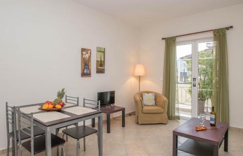 a living room with a table and a dining room at Dora's Apartments in Laganas