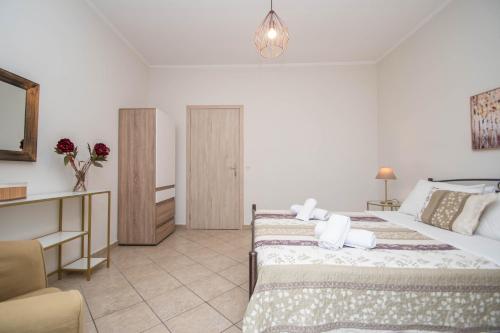 a bedroom with two beds and a desk and a room at Dora's Apartments in Laganas