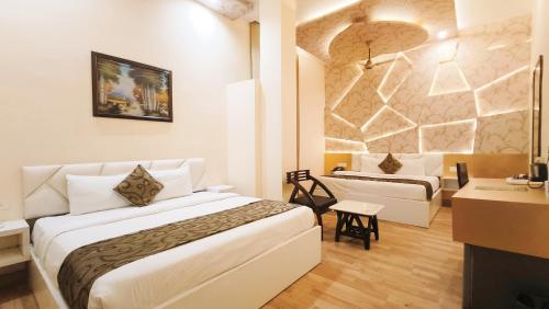 a hotel room with a bed and a desk at Hotel Sallow Royal Suites in Amritsar