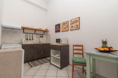 a small kitchen with a counter and a table at Dora's Apartments in Laganas