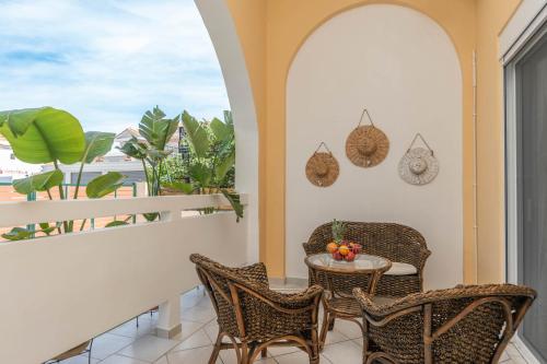 a balcony with a table and chairs and a view of the ocean at Dora's Apartments in Laganas