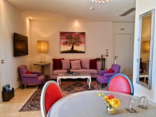 a living room with a pink couch and purple chairs at Castello di Velona Resort, Thermal SPA & Winery in Montalcino