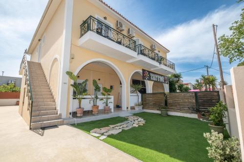 a house with a balcony and a yard at Dora's Apartments in Laganas