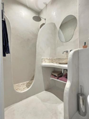 une salle de bain blanche avec un lavabo et un miroir dans l'établissement Appartement type Méditerranéen, à Marseille