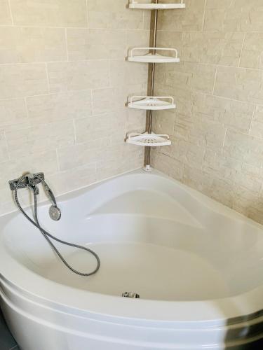 une baignoire blanche avec douche dans une salle de bain dans l'établissement VILLA 250m2 Montpellier Sete Palavas, à Mireval