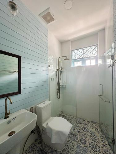 a bathroom with a toilet and a sink and a shower at Wiengket Heritage 1964 in Bangkok