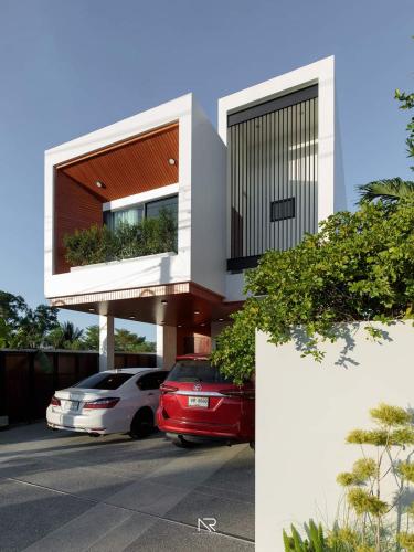 a house with two cars parked in a parking lot at Touchwarin kohyor pool villa ธัชวารินเกาะยอพูลวิลล่า in Songkhla