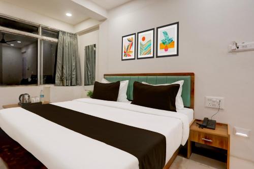 um quarto com 2 camas e uma janela em OYO HOTEL R CK INN em Rajkot