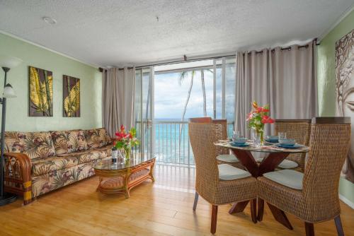 a living room with a table and a couch at Magic Sands condos in Kailua-Kona