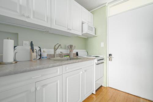 a kitchen with white cabinets and a sink at Magic Sands condos in Kailua-Kona