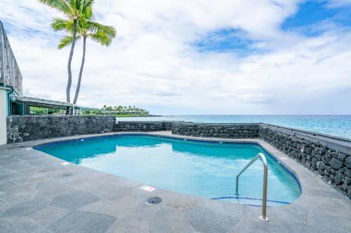 a swimming pool with the ocean in the background at Magic Sands condos in Kailua-Kona