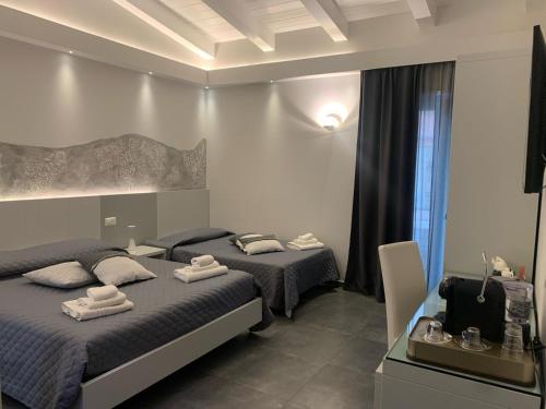 a bedroom with two beds with towels on them at JeVi Stars Rooms in Tropea