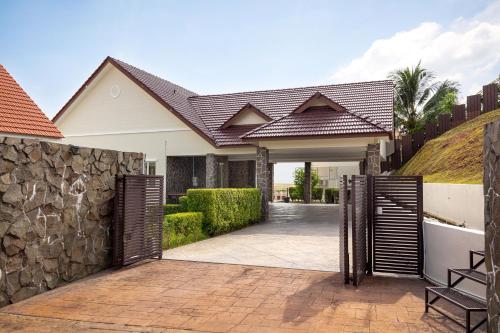 ein offenes Tor zu einem Haus mit einer Steinmauer in der Unterkunft Panoramic Seaview Holiday Home - Batu Ferringhi in Batu Feringgi