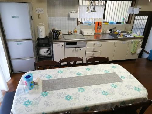 eine Küche mit einem Tisch und eine Küche mit einem Kühlschrank in der Unterkunft Satoyama no Yado Kei-House - Vacation STAY 55796v in Shikokuchuo