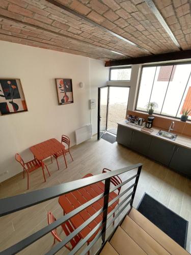 a living room with a table and chairs and windows at Le Relais de 40 Sous in Aubergenville