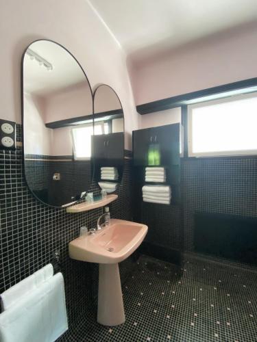 une salle de bain avec un lavabo et un miroir dans l'établissement APPARTEMENTS VINUALES, à Lourdes